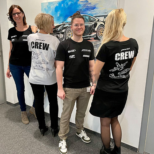 im Bild vier Mitarbeiter*innen von Pankl, sie tragen schwarze Shirts mit dem VOI fesch Motiv von Künstler Konrad Wartbichler, eine Mitarbeiterin trägt ein weißes Shirt mit dem Motiv