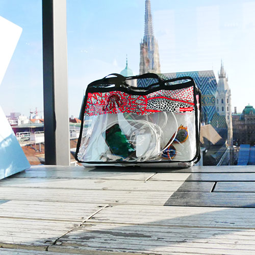 BIBLIOBAGS Tasche mit VOI fesch Design von Künstlerin Patricia Hütter, vorne im Bild; im Hintergrund ist der Stephansdom in Wien zu sehen